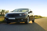 A sleek, freshly cleaned car shining under soft golden light with a deep black backdrop.