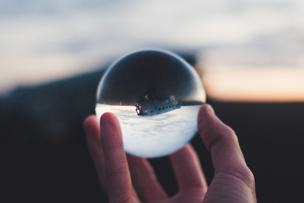 person holding glass ball