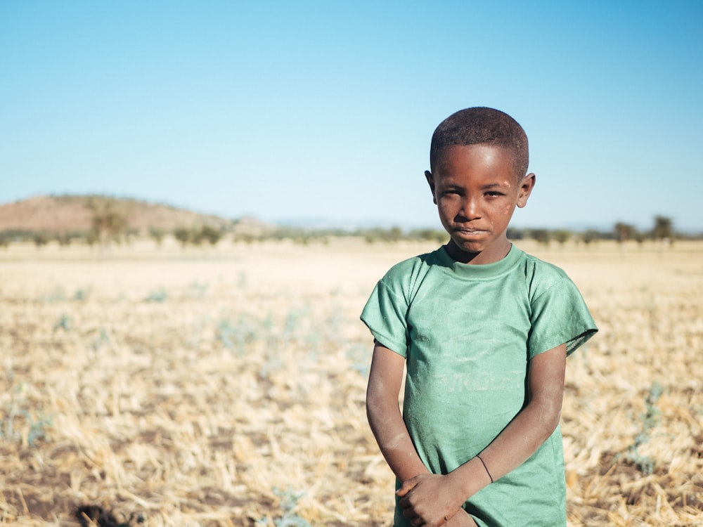 boy standing and holding his arm