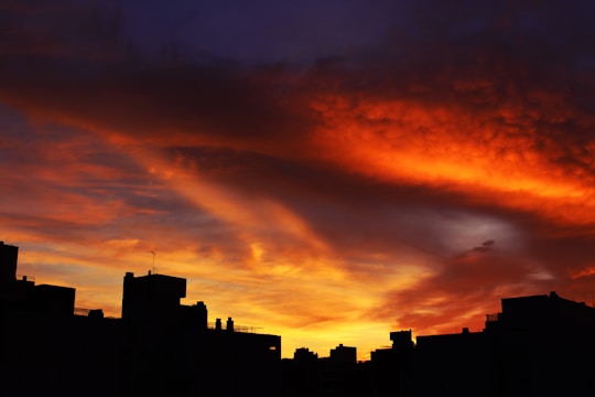 A sunset cityscape photograph with vibrant orange and purple hues.