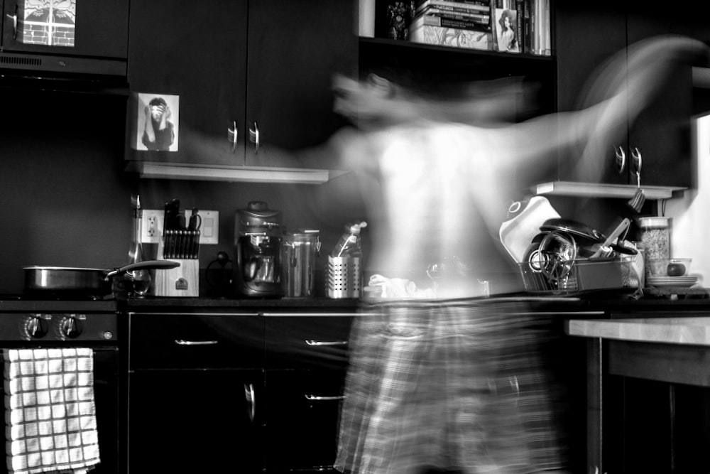man moving at the kitchen in grayscale photography