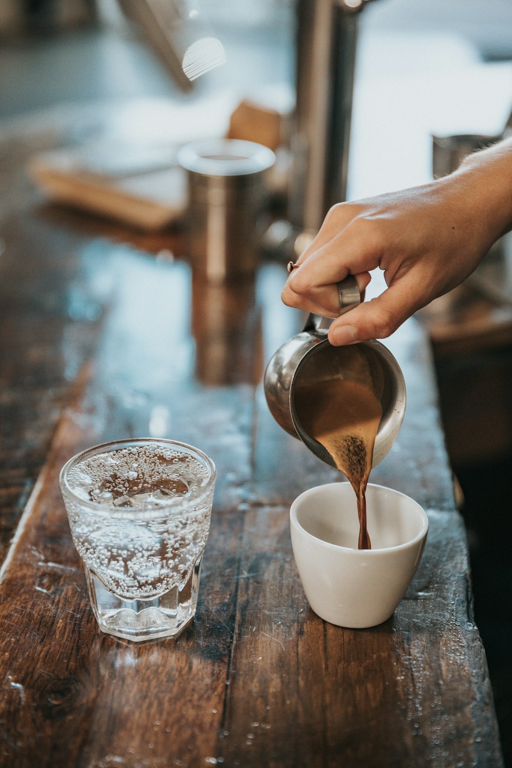 マグカップにコーヒーを注ぐ人