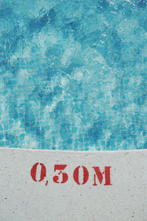 Technician performing water quality analysis with testing strips beside a residential pool