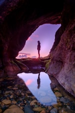 man standing in front of cave