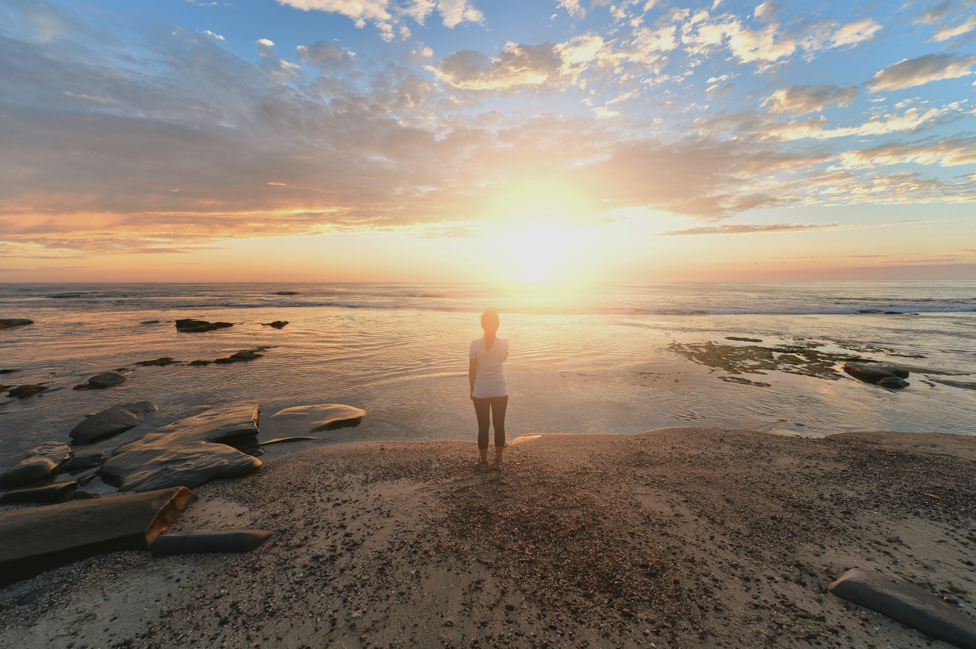 Woman shoreline sunrise.