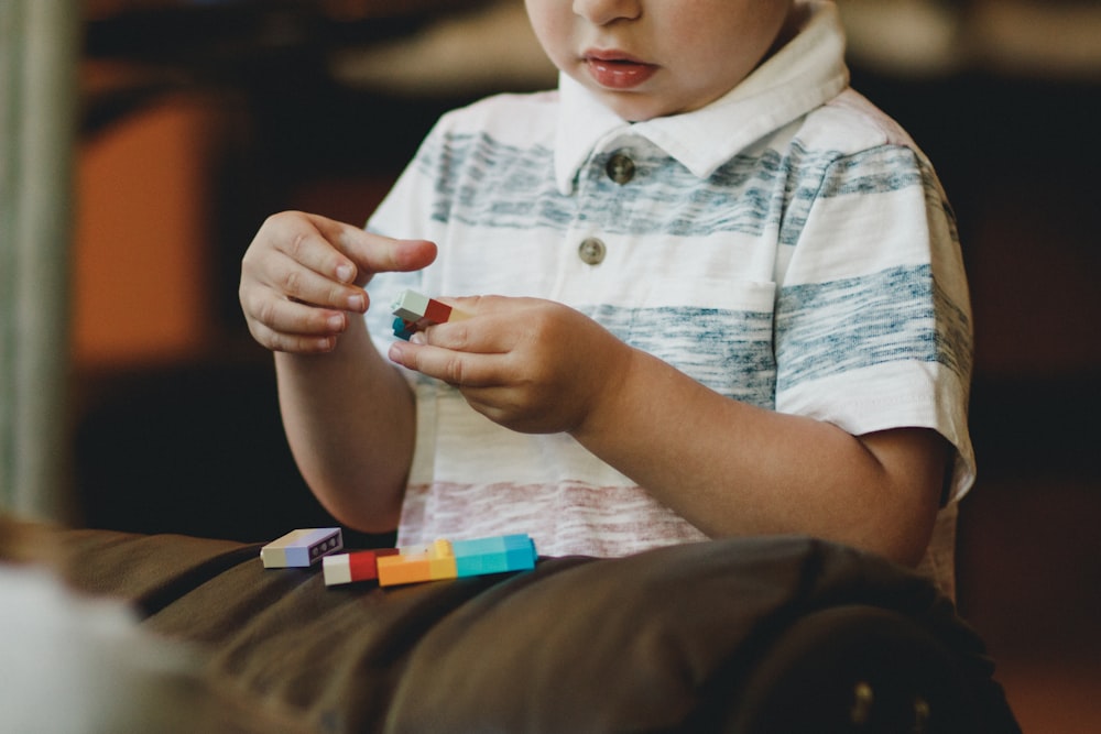 niño sosteniendo el juguete del bloque