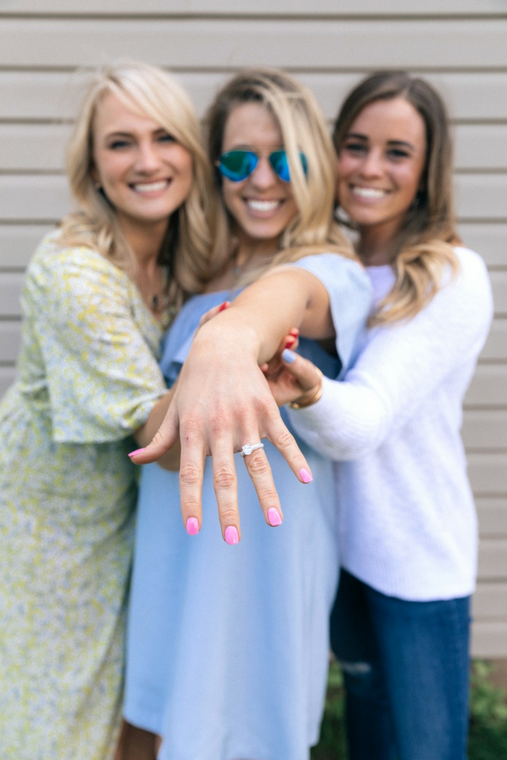 two women holding woman's hand in the middle