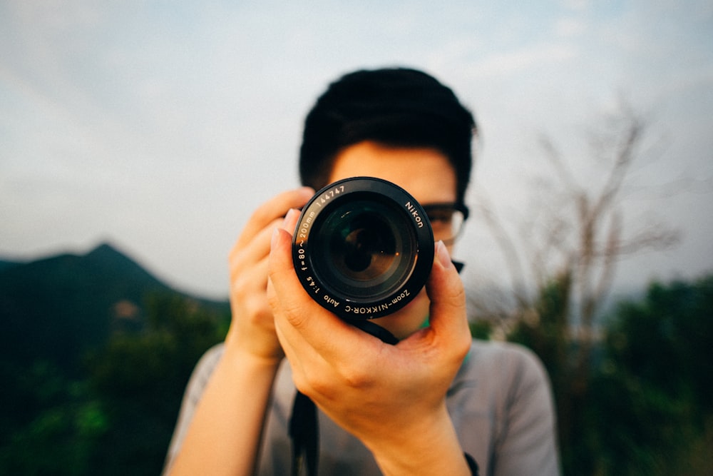 homem usando câmera DSLR