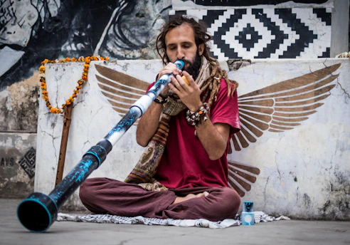 A vibrant didgeridoo performance in the warm orange and blue tones reflecting the Didge Wiggertal logo colors.