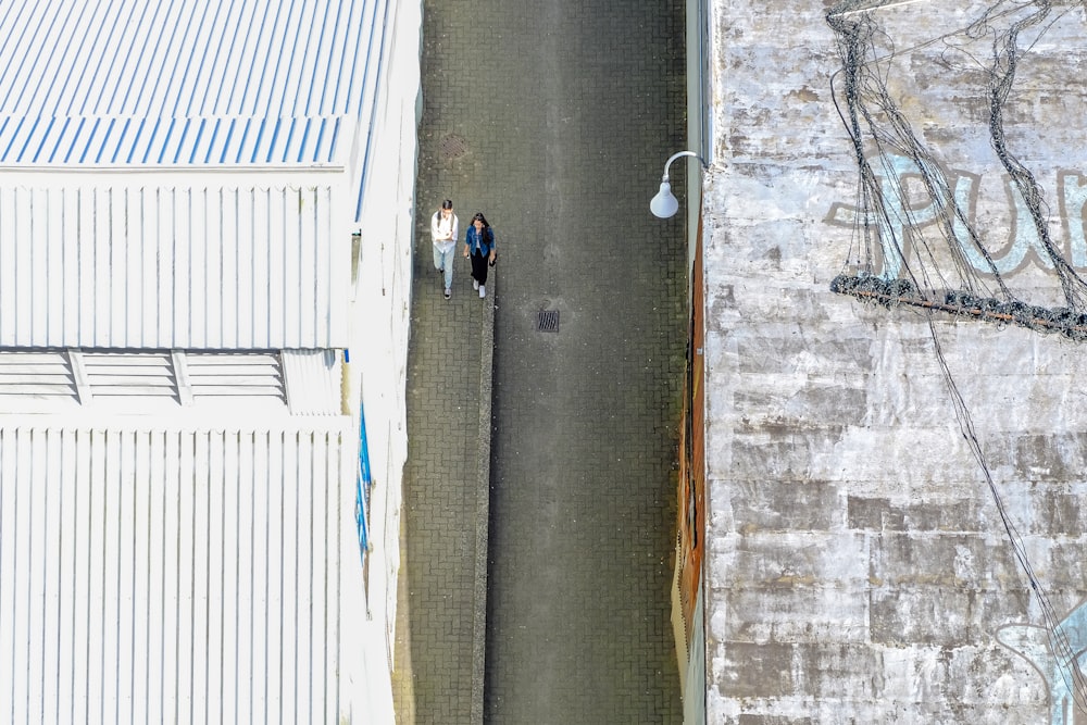 two women walking on road between houses