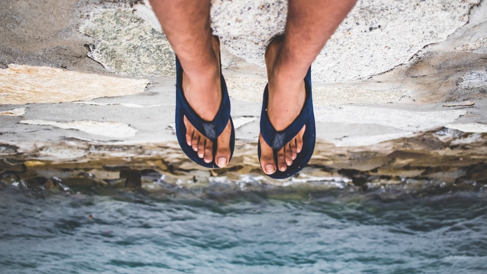 photo of person sitting on cliff