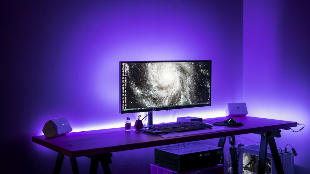 flat screen computer monitor on brown computer desk