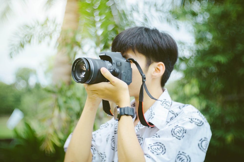 person holding black DSLR camera