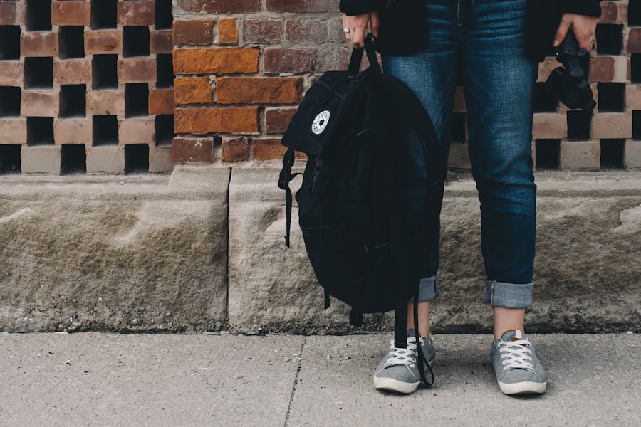 woman holding a black backpack