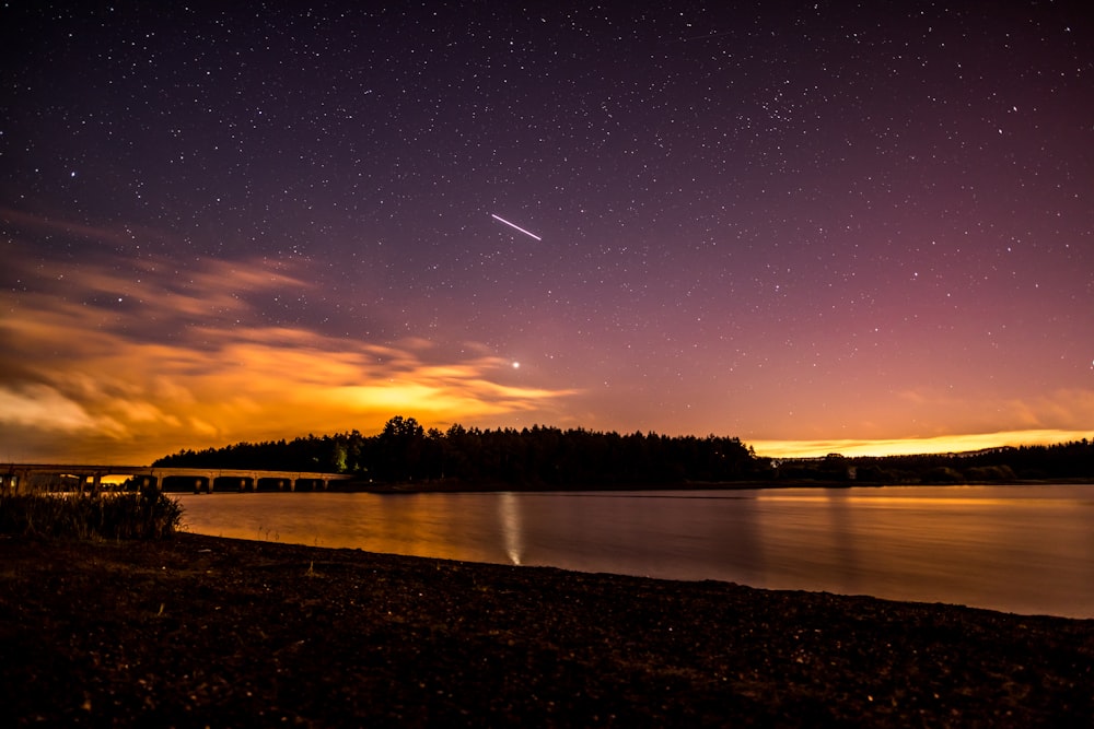 silhouette photo of island and falling star