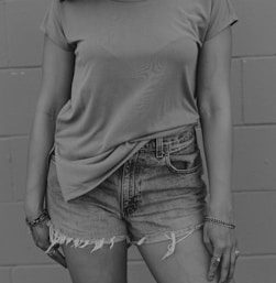 grayscale photography of woman wearing t-shirt and denim short shorts