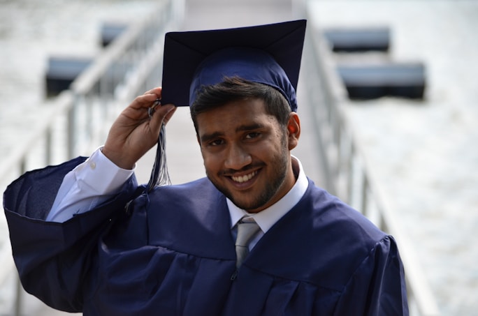 A smiling Indian student in graduation attire, reflecting joy and achievement in abroad education