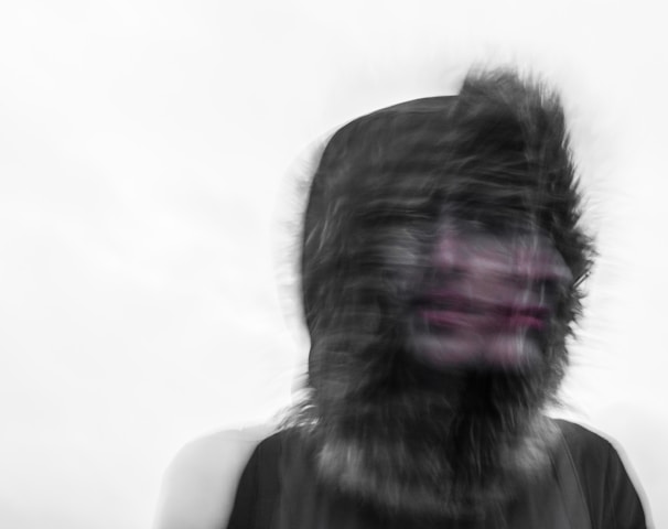 Creepy blurred photo of a person's face and a furry hood