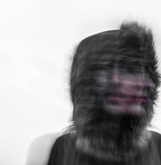 Creepy blurred photo of a person's face and a furry hood