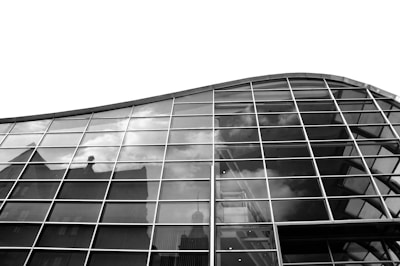 Elegant commercial building facade with glass windows reflecting the city.