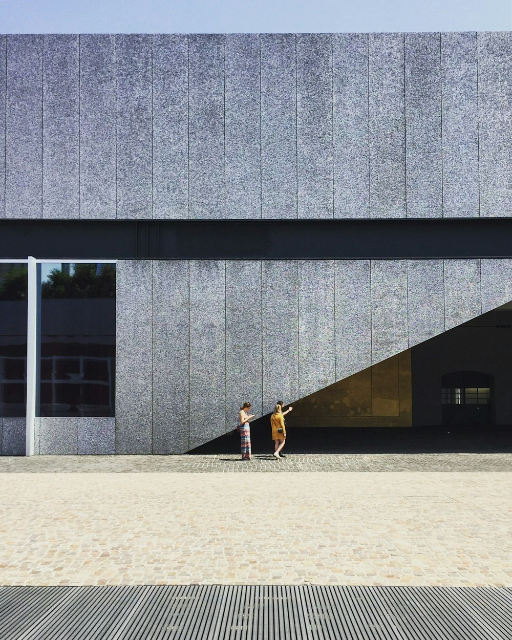 two person beside gray wall