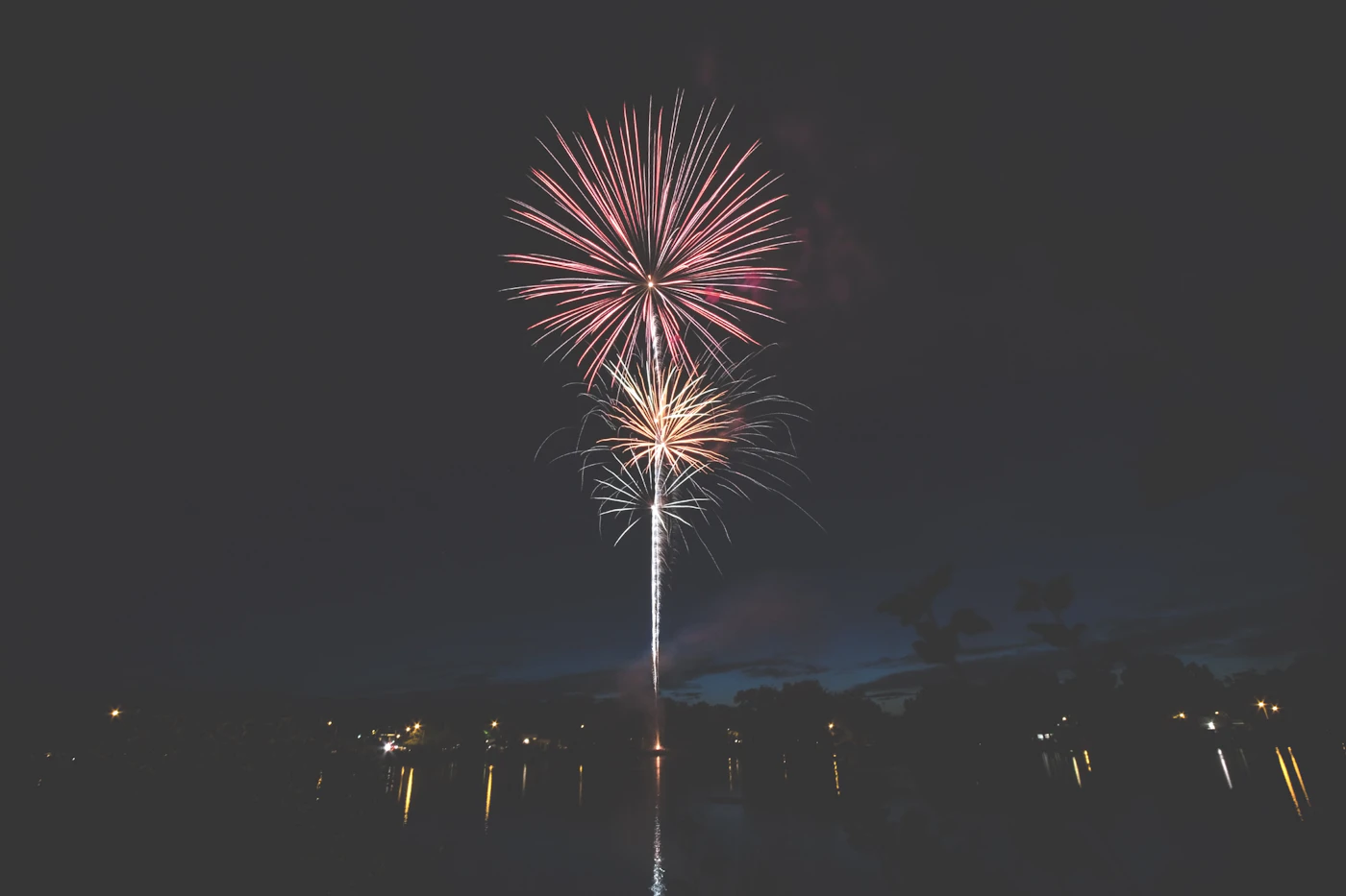 Fuegos artificiales sobre un lago de noche
