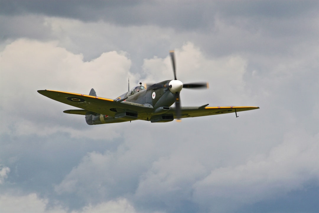 gray and brown airliner on air under blue and white sky, vintage propeller plane