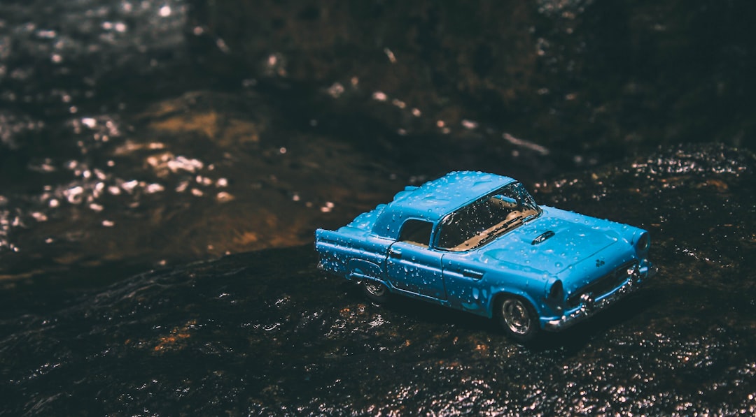 tilt shift photo of blue car die-cast