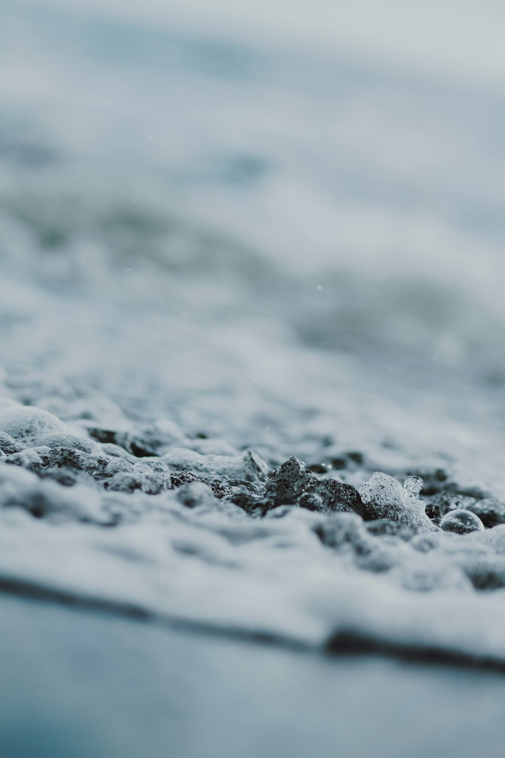 a blurry photo of water and rocks in the ocean