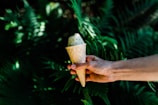A refreshing ice cream sundae surrounded by green foliage.