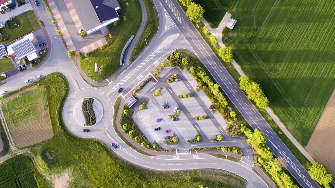 aerial photography of cars on road at daytime, Drone view of the parking lot by the roundabout