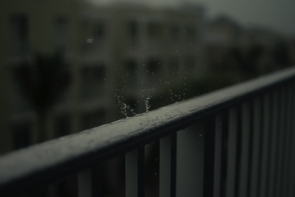 timelapse photo of water drop on black wooden fence