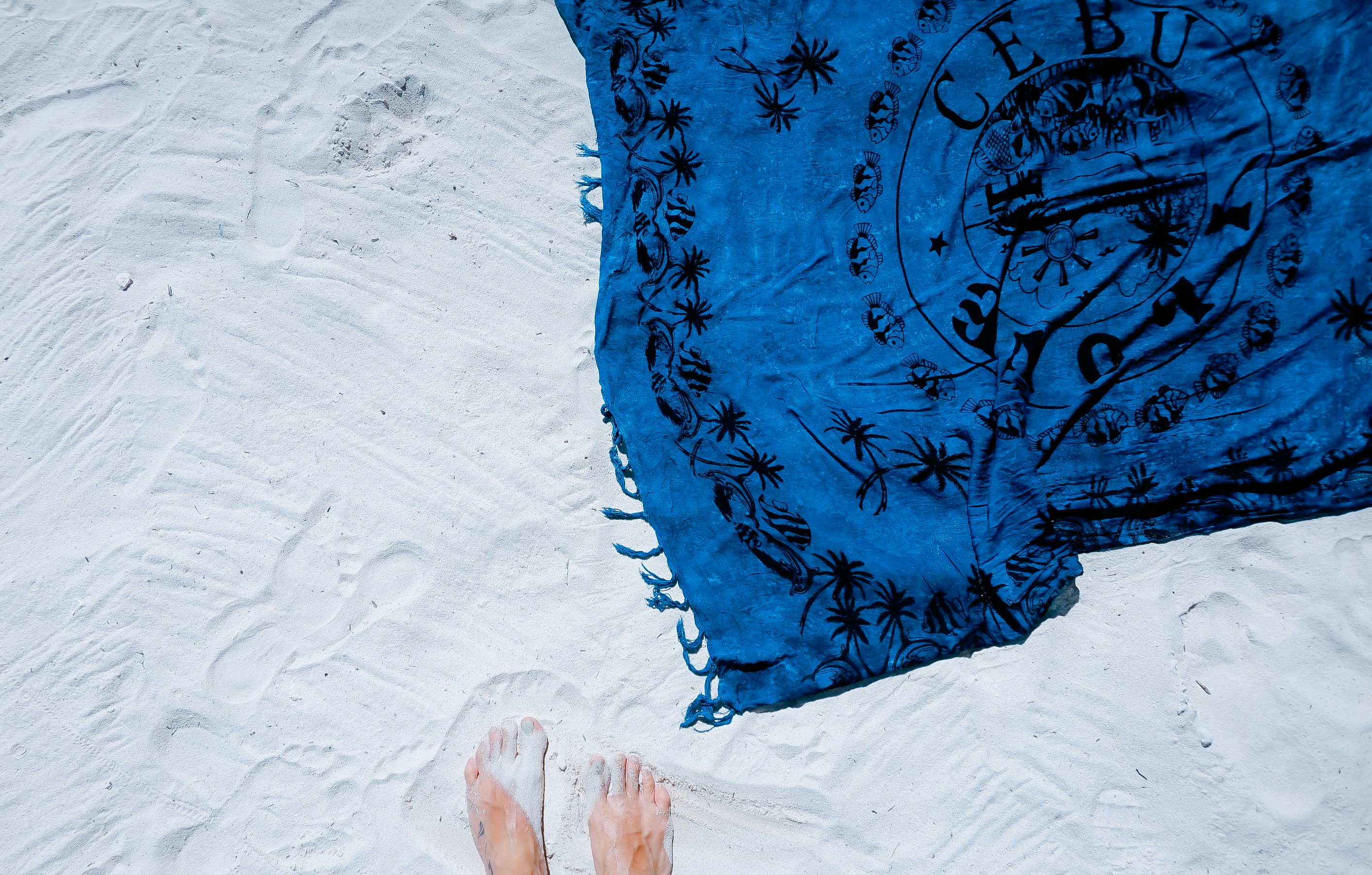 blue and black floral scarf on white sand, Standing in the fine sand