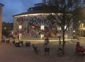 A vibrant street mural with bold colors and urban motifs at dusk.