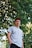 man putting his hand inside his pocket under the tree