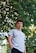 man putting his hand inside his pocket under the tree