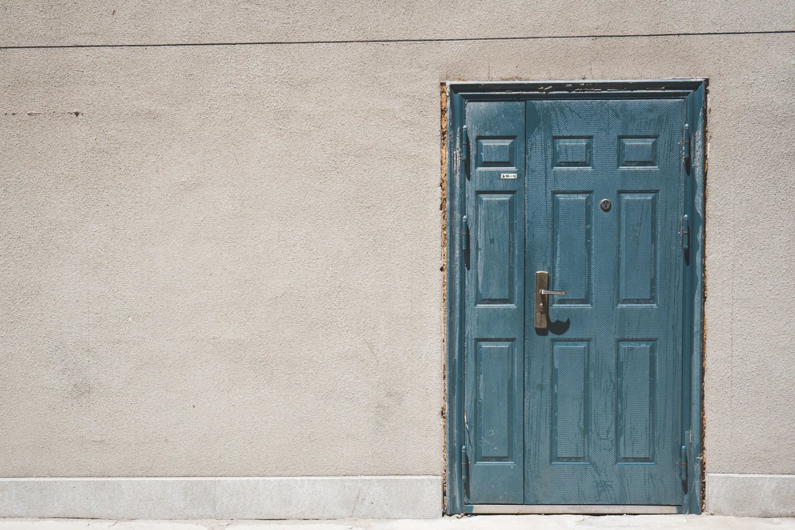 A single closed door at the end of a long hallway