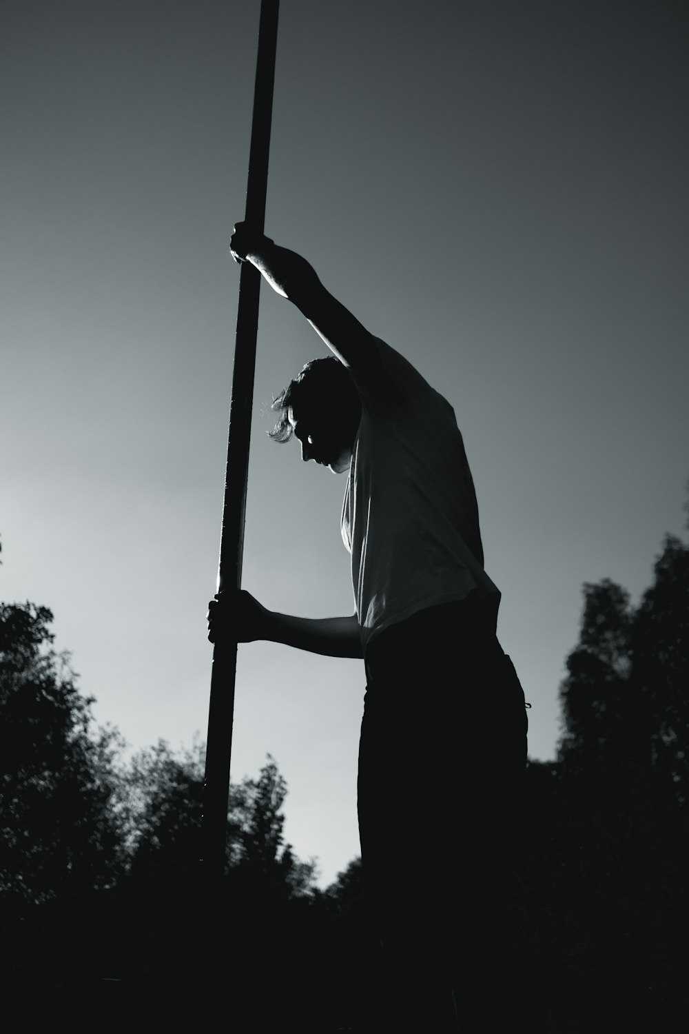 man in white shirt holding pole