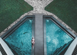 bird's eye view of woman lying on floor beside swimming pool