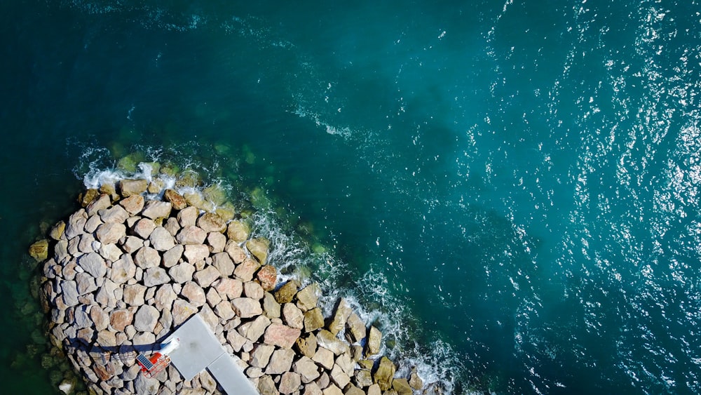 aerial view of rocks beside body of water