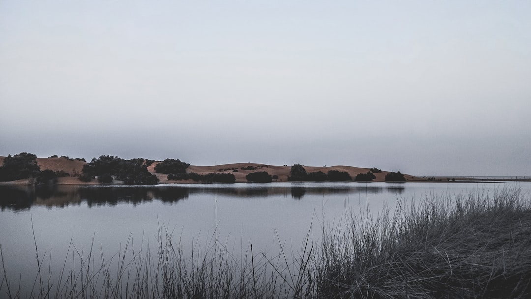 brown mountains beside body of water during daytime