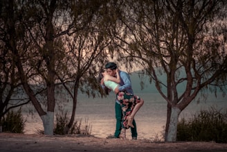 couple kissing in front of trees