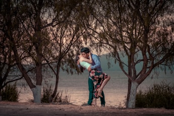 couple kissing in front of trees