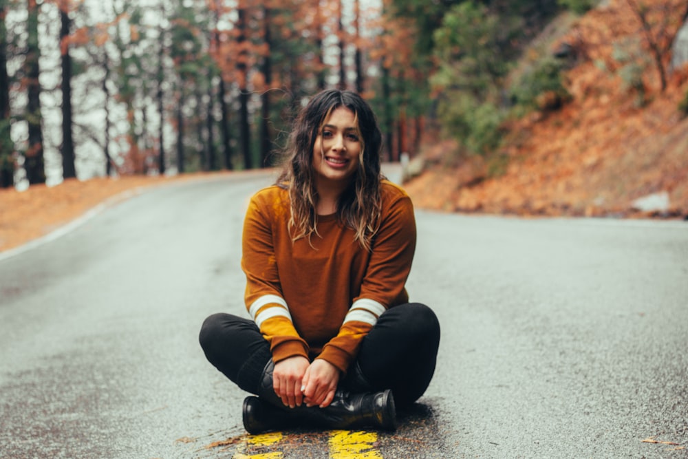 woman sitting on concrete road