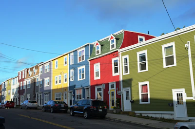 Neighborhood street lined with charming houses under a bright blue sky