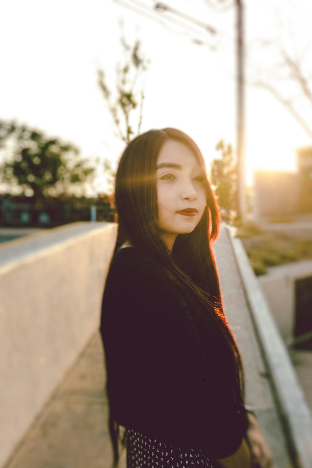 woman in black blazer beside white wall