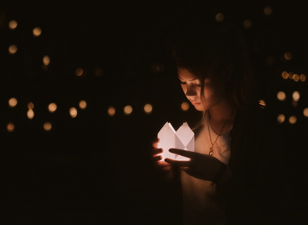 Fotografía bokeh de mujer sosteniendo linterna de papel