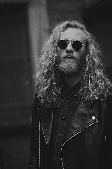 grayscale photo of man in leather jacket