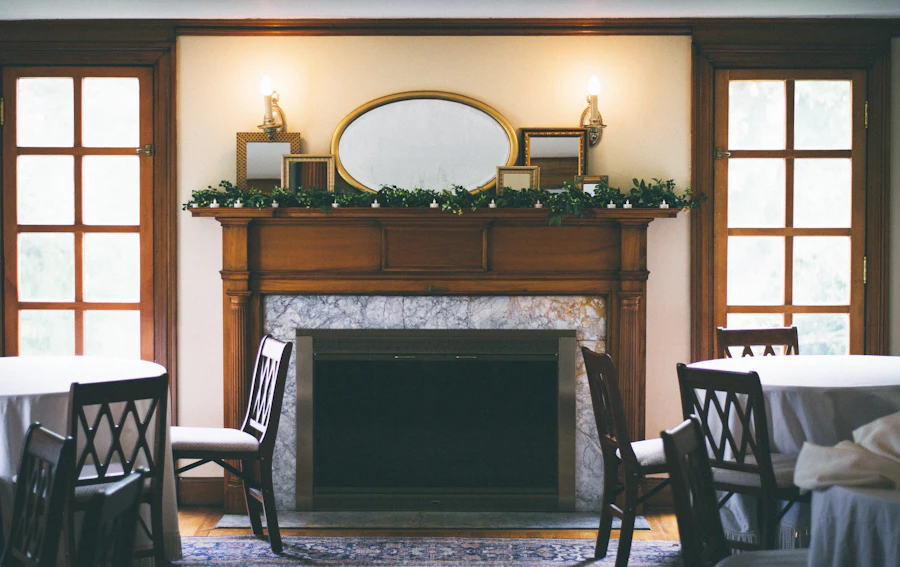 The long room, laid with round tables and chairs beside the fireplace