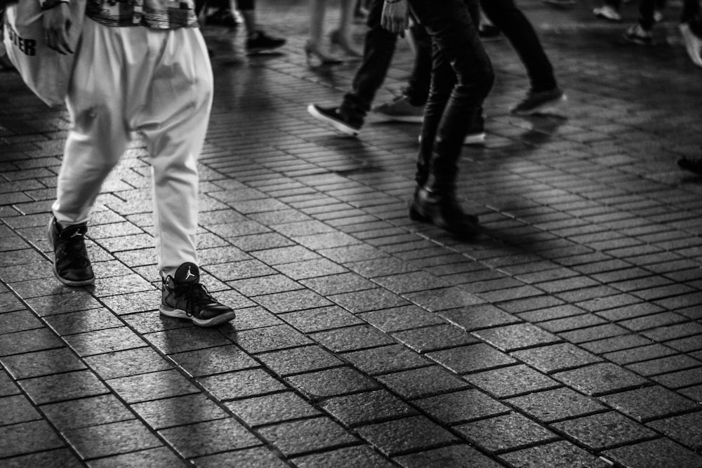 hombres caminando sobre suelo de baldosas de cemento